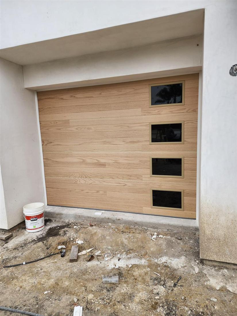 New oak-tone garage door being fitted on a new build