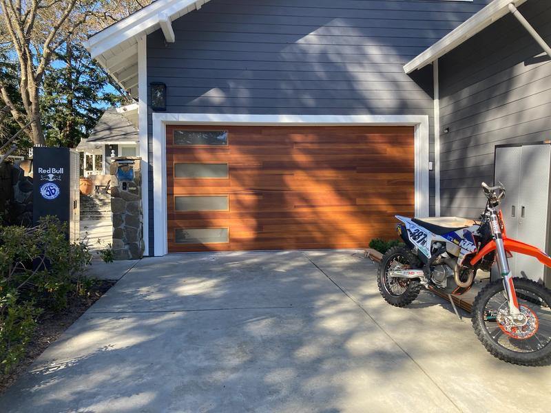 Wood-tone garage door on a modern driveway